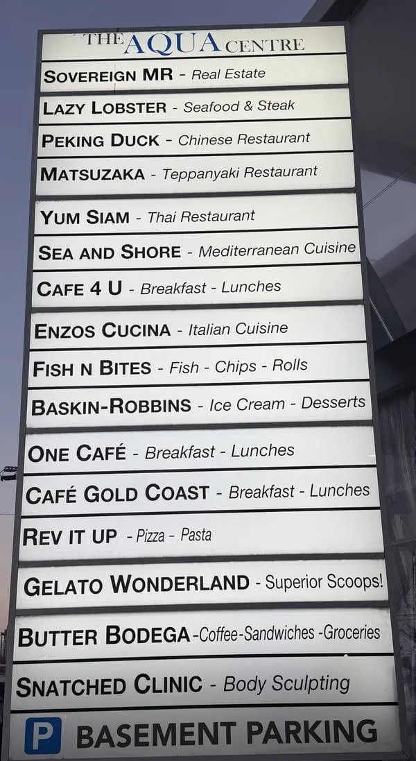 The Aqua Centre pylon sign listing tenants, with Basement Parking at the bottom